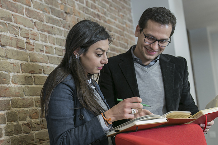 Two students stand and discuss course material