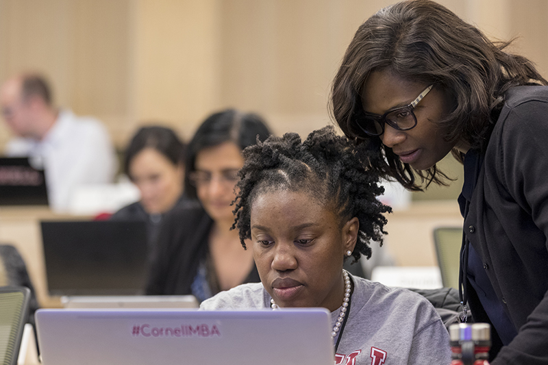 Two women look at a computer screen together