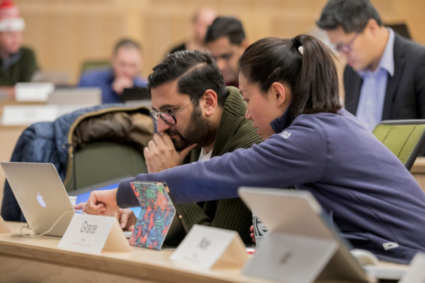 Cornell Johnson Graduate School of Management students in a classroom, pointing at a screen