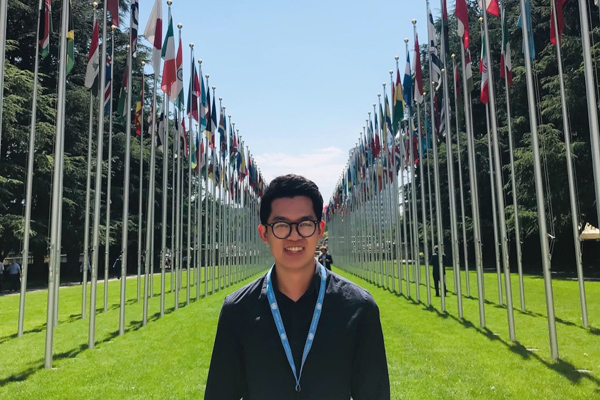 Feam standing among two rows of flags outdoors