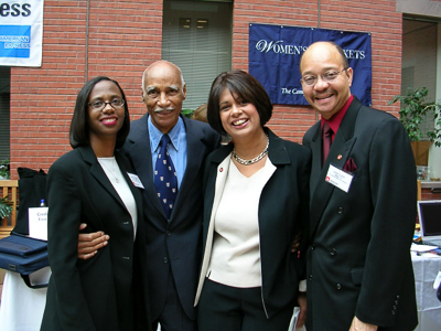 Four people pose for a photo in the atrium