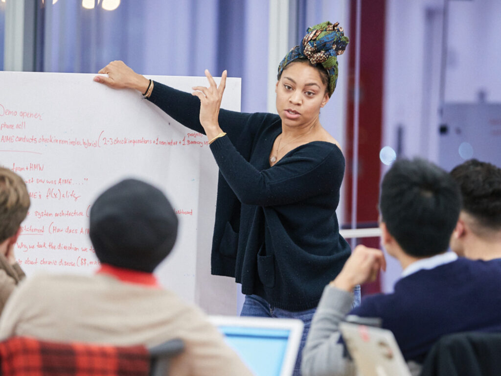 Student presenting an idea on a whiteboard
