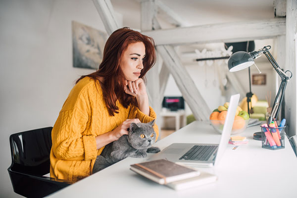 Woman working from home and petting an animal
