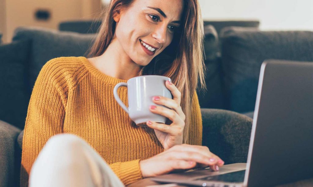 person drinking coffee with laptop