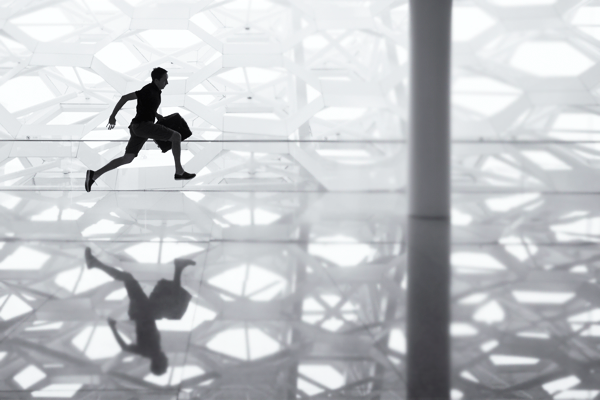 silhouette of man running with a brief case at airport
