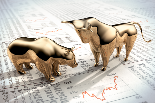 gold bulls figurines on stock market sheet
