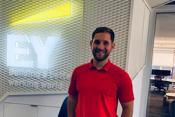 A picture of Benjamin Goulet standing next to the EY logo