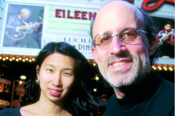 photo of Barry Massarsky and Nari Matsuura standing in front of a theatre marquis.