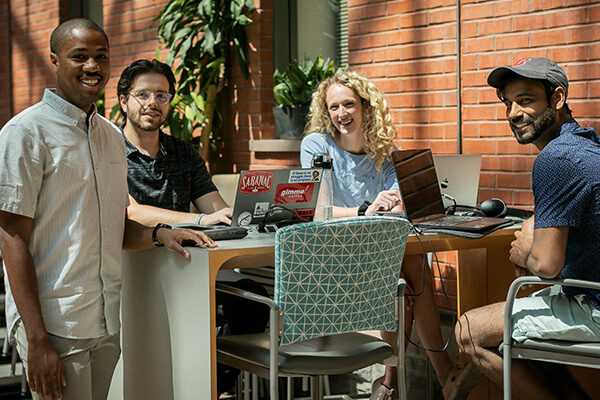Four MBA students gathered around a table in Sage Hall.