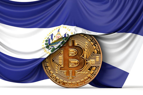 Image of a round, metal Bitcoin draped in the flag of El Salvador.