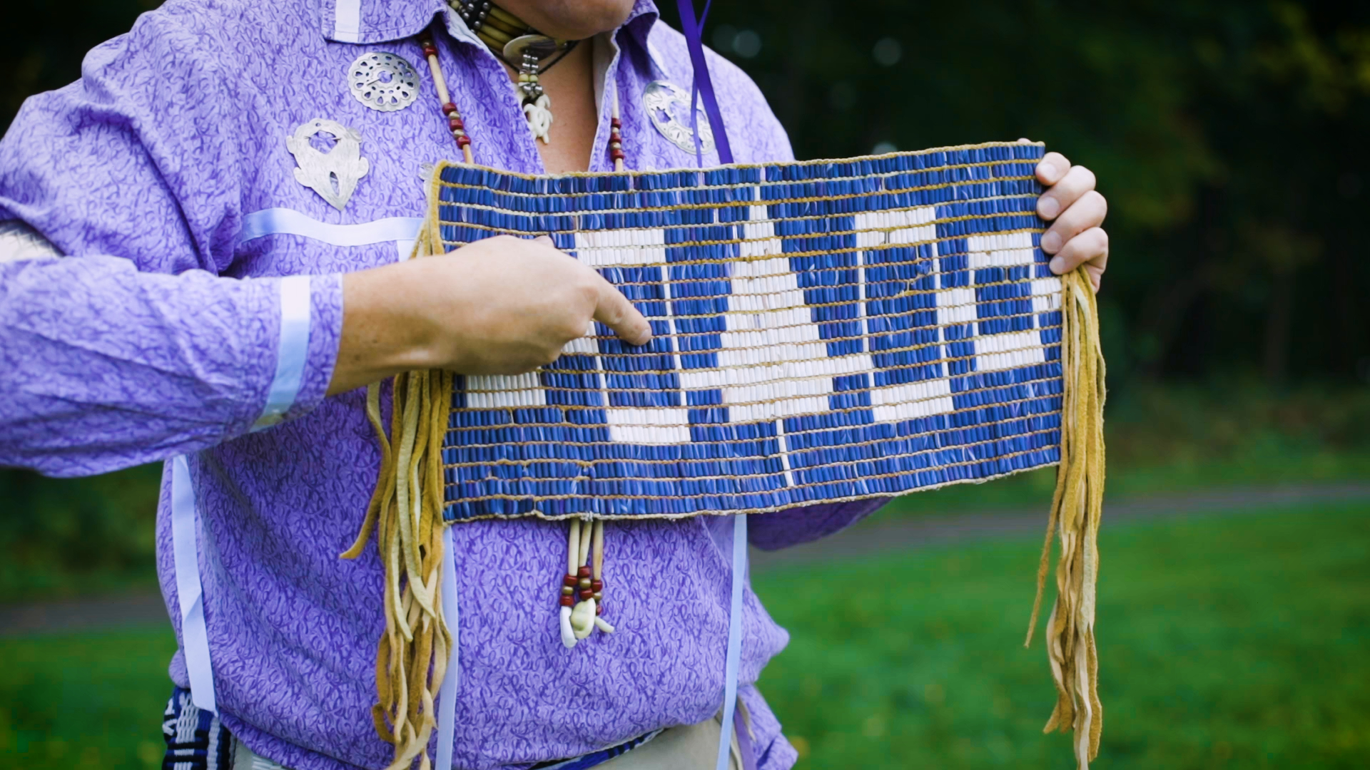 Onodagan man holding a replica Hiawatha belt