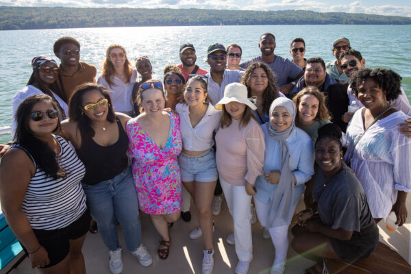 Group of MBA students on a boat with lake in background.