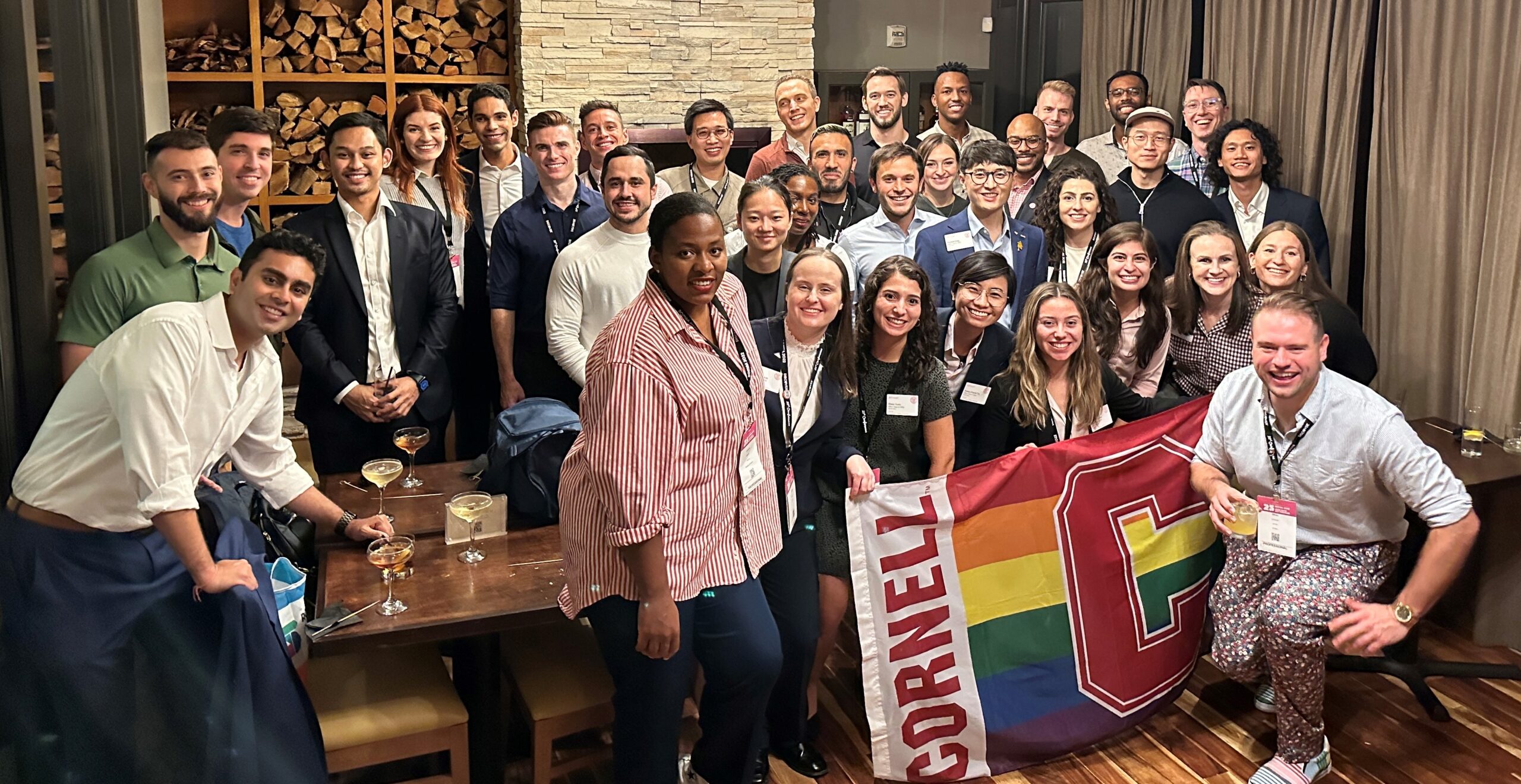 Group of Johnson student and alumni holding a rainbow Block C flag