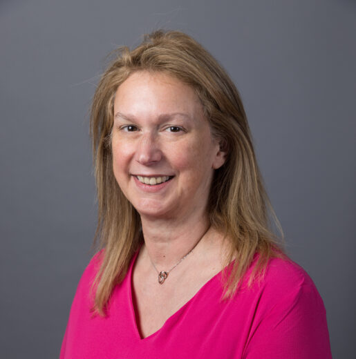 Headshot of white woman wearing pink.