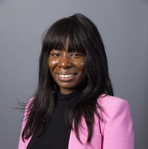 Headshot of Black woman wearing a pink power suit