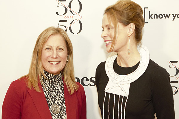 two women standing next to each other and smiling.