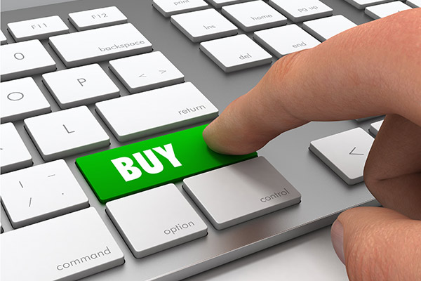 photo of a keyboard with a human index finger about to click a green key marked "BUY".