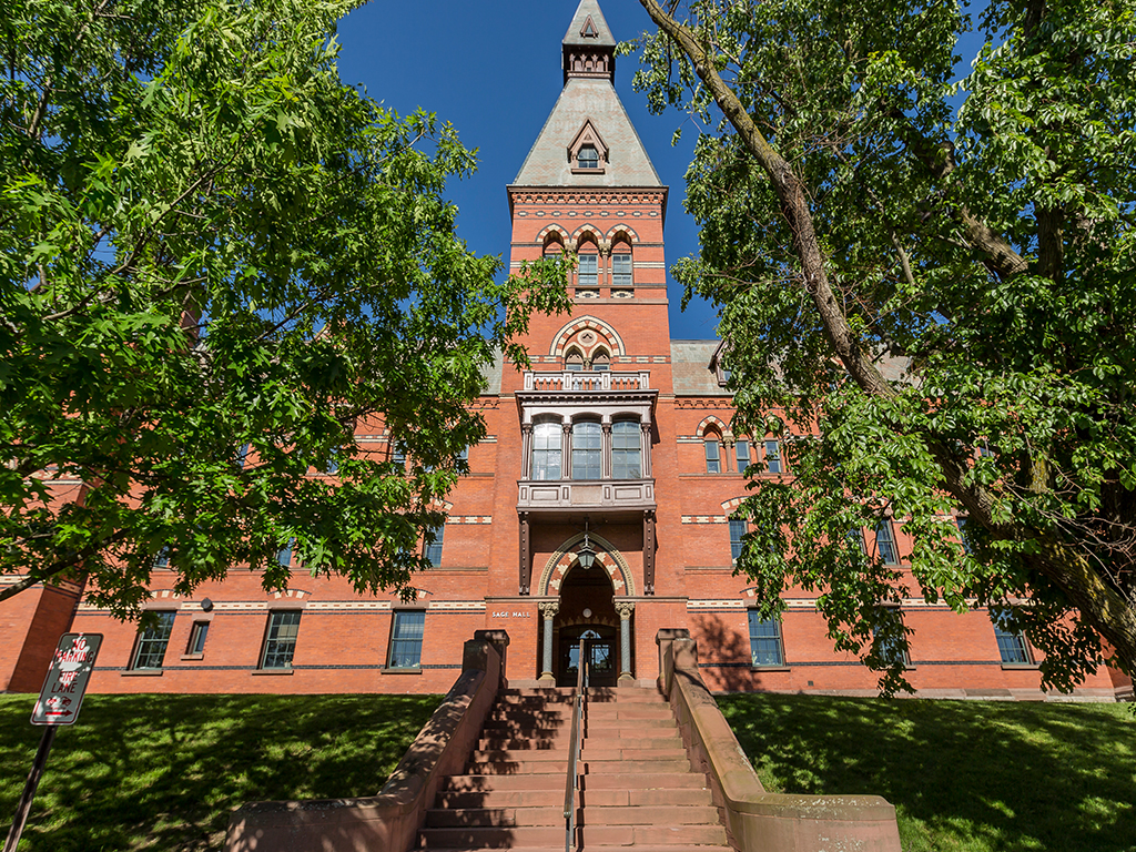 Facade of Sage Hall flanked by two trees.