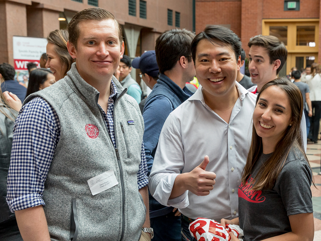 Three people smile at the camera.