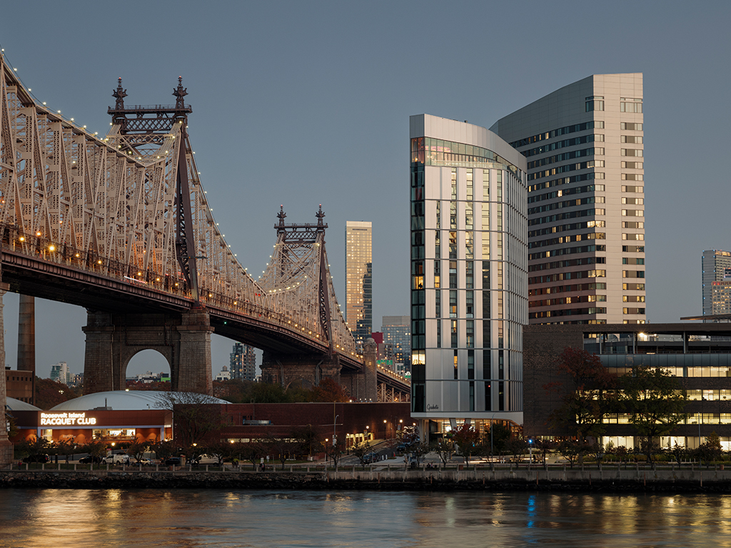 Roosevelt Island skyline lit up at dusk.