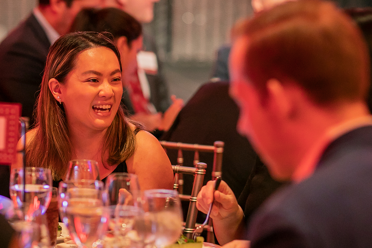 Woman smiling sitting at a table at a formal dinner.