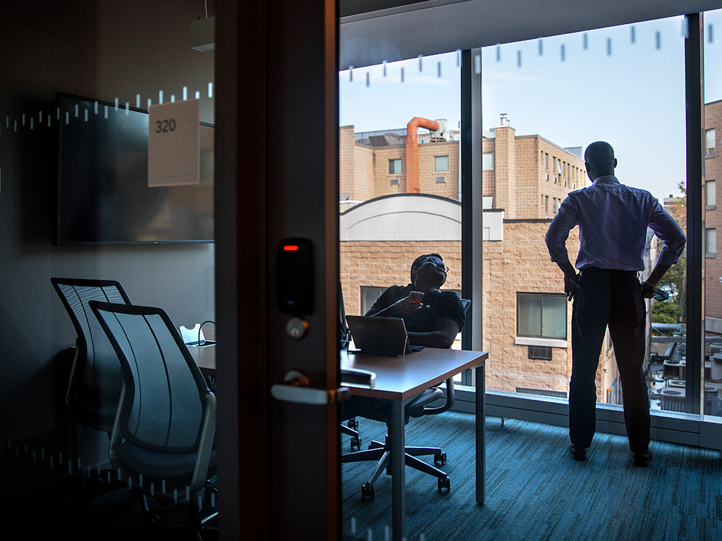 Two people in a focus room with a wall of windows.