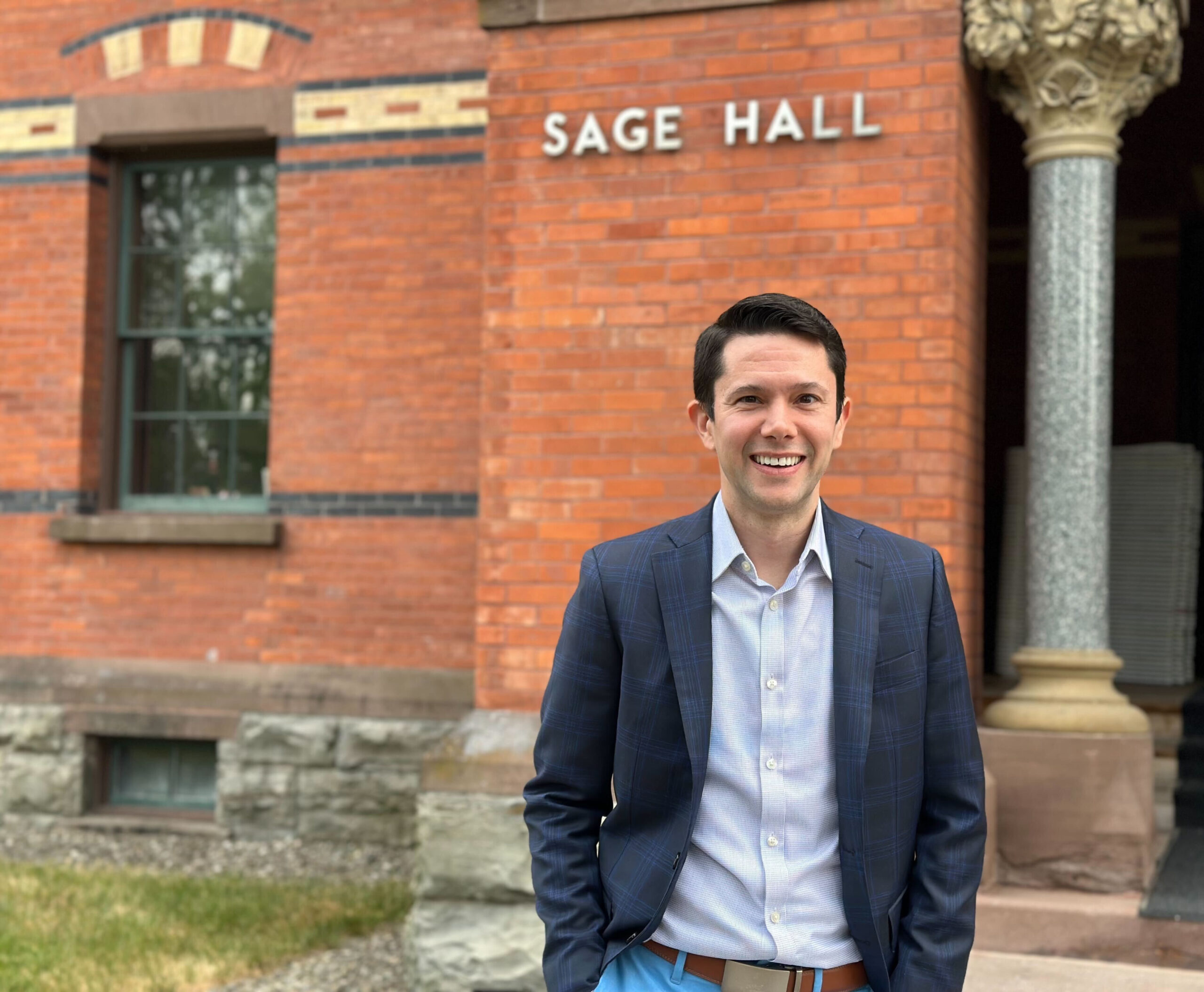 Photo of Brian Balduzzi standing in front of Sage Hall on Cornell's campus.