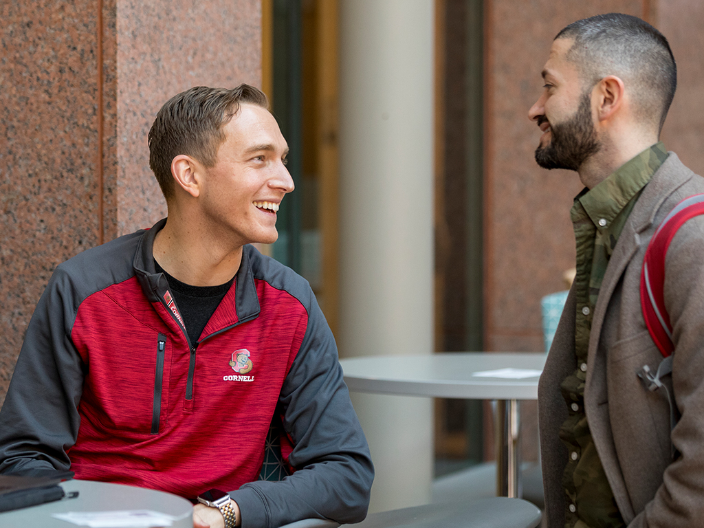 Two people smiling and talking with each other.