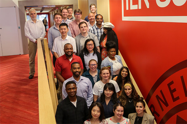 Members of the 2023 JSSA cohort pose for a group photo on a flight of stairs.