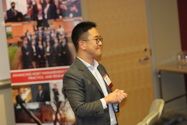 side view of a man standing and looking out at an audience.