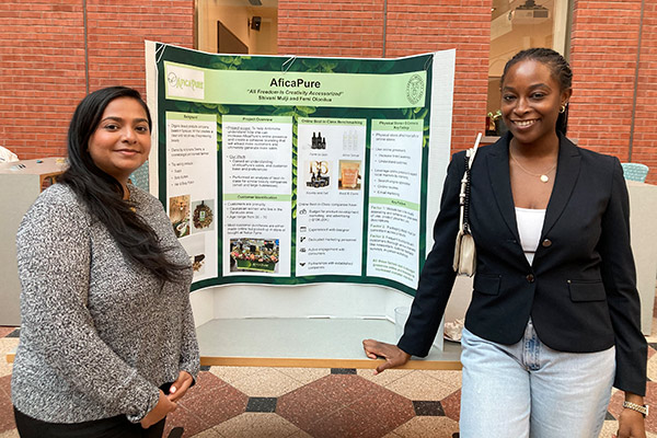 A picture of Shivani Mulji and Femi Olonilua in front of a poster board in Sage Hall.