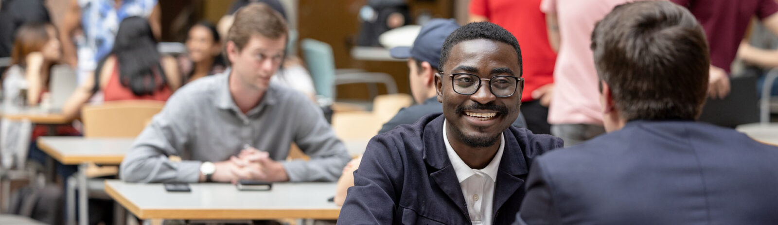 Two students having a discussion around a table.