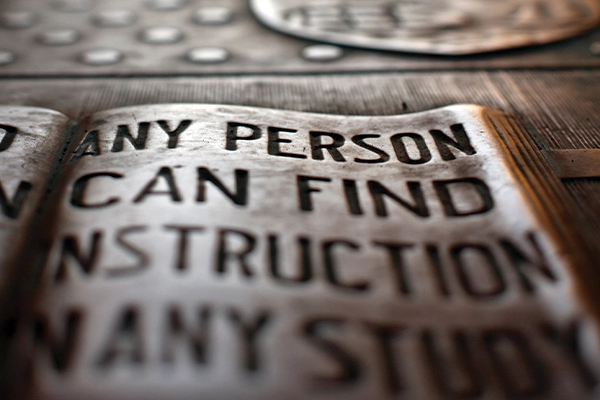 The Cornell University founding principle engraved on an open book.