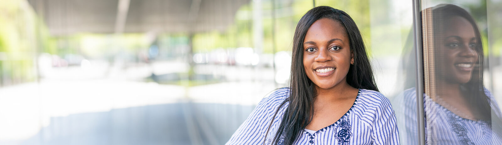 Graduate student smiling in front of Breazzano Family Center.
