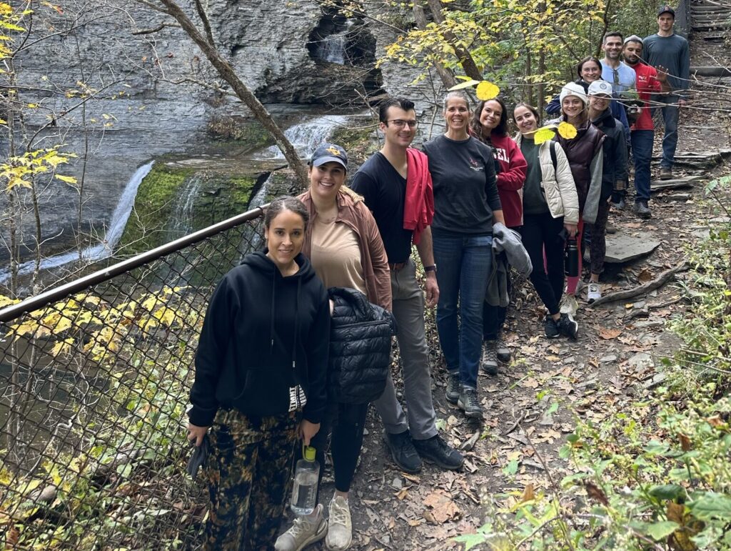 Students pose in front of a waterfall
