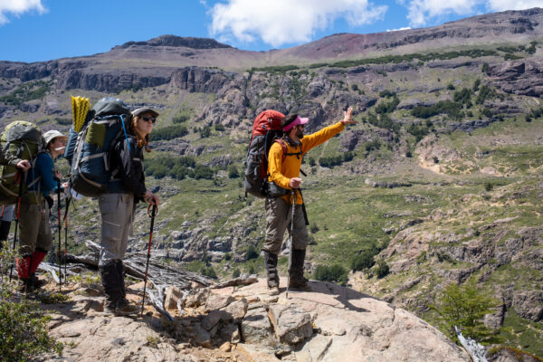 Students stand on a rock formation in Patagonia.