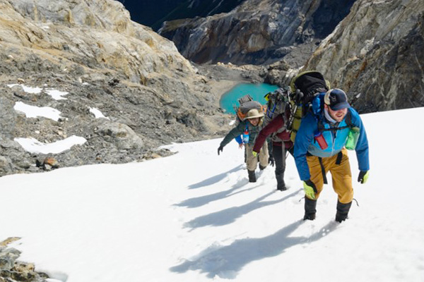 Students climb up a snowy mountainside in Patagonia.