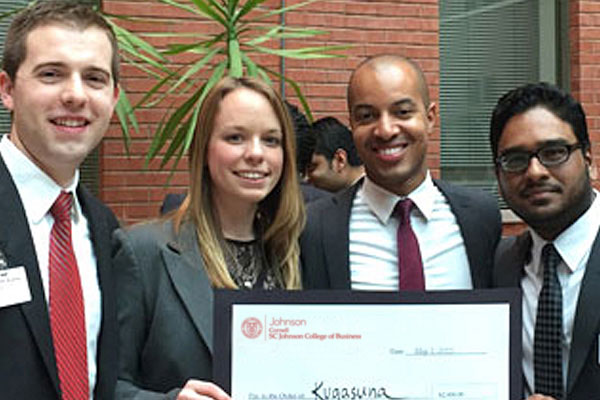 MBA students post with a check.
