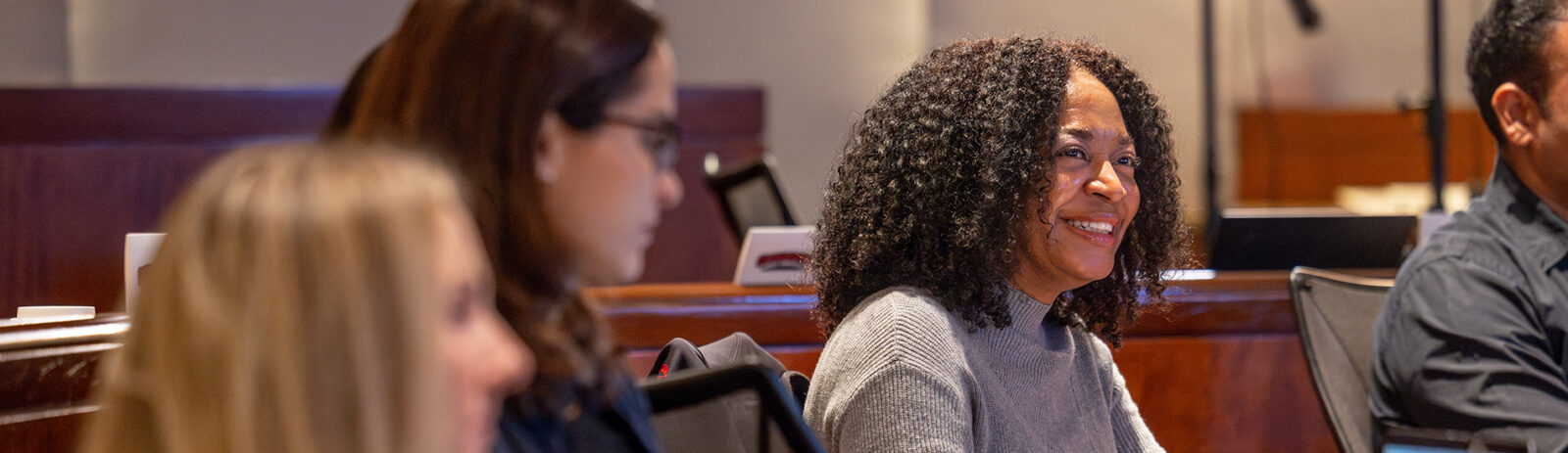 Student sitting in class smiling.