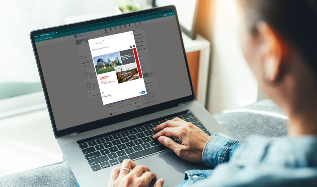 Person working on a laptop, sharing a post on LinkedIn.