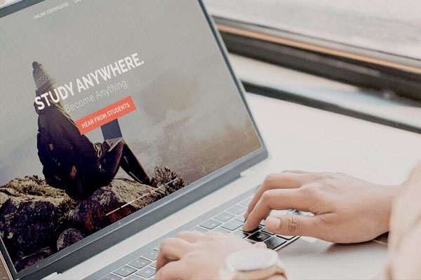 A person’s hands typing on a laptop.