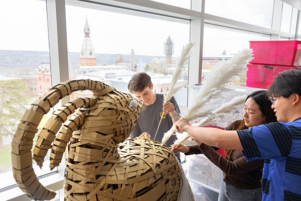 Image of two male and one female students assembling decorations in the Silver Birch Suite in Statler Hall