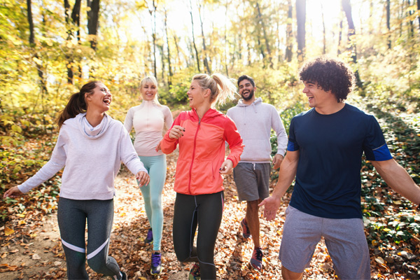 People jogging on a path in the wooods.