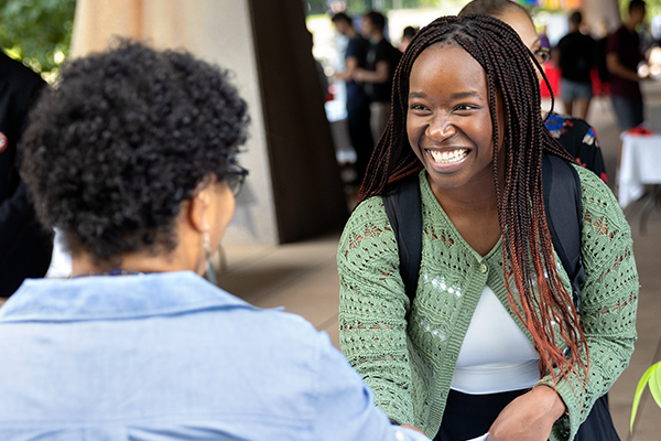 A student shaking hands with a person at a recruiting event.
