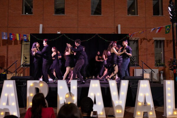 MBA students dance on a stage during Carnaval